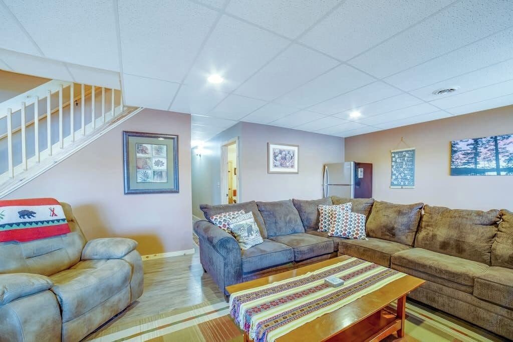 A living room with a sofa set, a coffee table, and a staircase.