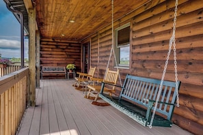 A wooden cabin with a porch, wooden benches, and a swing. - 3BR cabin home withlake views, soaking tub - dogs ok (Dundee)