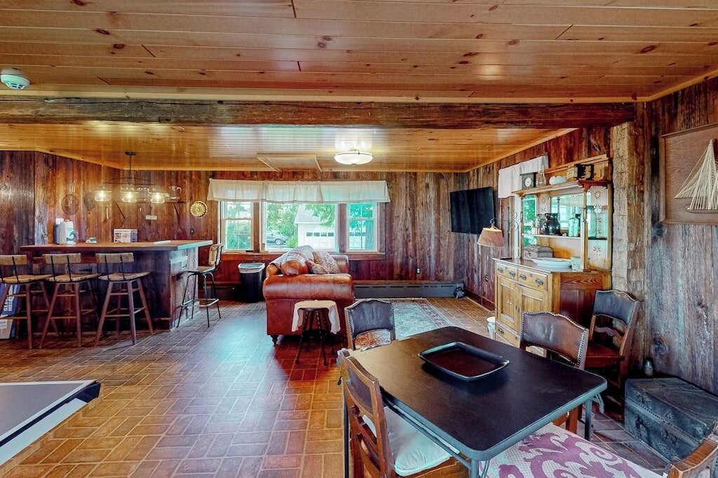 A rustic interior with a bar area, seating, and a fireplace.