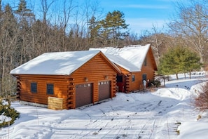 A log cabin with a snow-covered roof, a garage, and a small porch area. - 3BR house, dog-friendly, gas fireplace, bbq, withd (Hague)