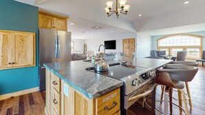 A spacious kitchen with a large island, wooden cabinets, and a stainless steel refrigerator. - 1BR home w/deck, countryside views & close to town (Penn Yan)