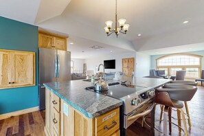 A spacious kitchen with a large island, wooden cabinets, and a stainless steel refrigerator. - 1BR home w/deck, countryside views & close to town (Penn Yan)