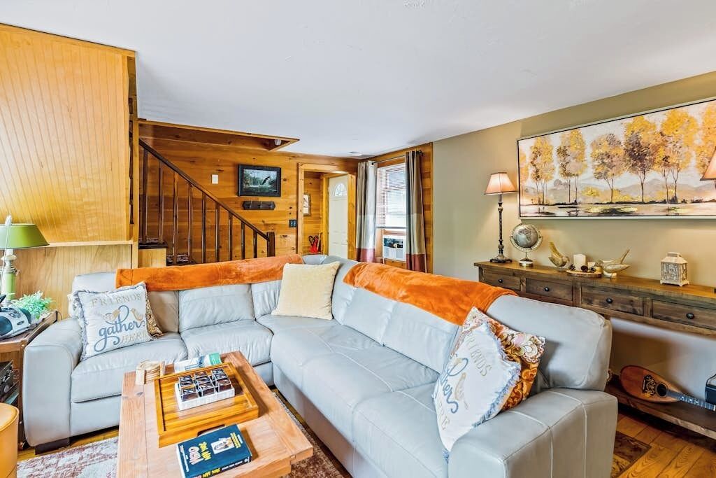 A living room with a sofa, coffee table, and a painting on the wall.