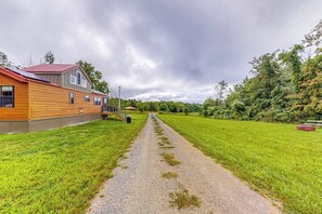 A gravel path leading to a wooden building with a red roof, surrounded by green fields and trees. - 1BR dog-friendly house close to Seneca Lake (Hector)