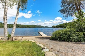 Une vue sur le lac, avec une jetée qui s’avance dans l’eau, entourée d’arbres et d’une zone herbeuse.