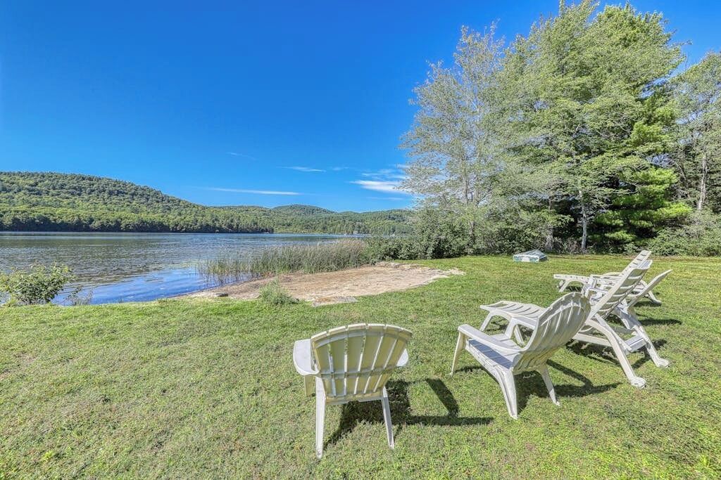 Vue sur le lac, avec espace extérieur aménagé et pelouse.