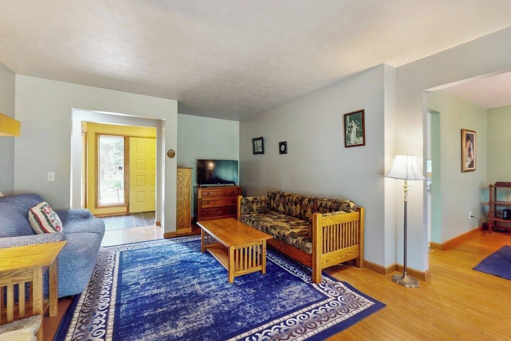 Un salon avec un canapé, une table basse, un téléviseur et une lampe.