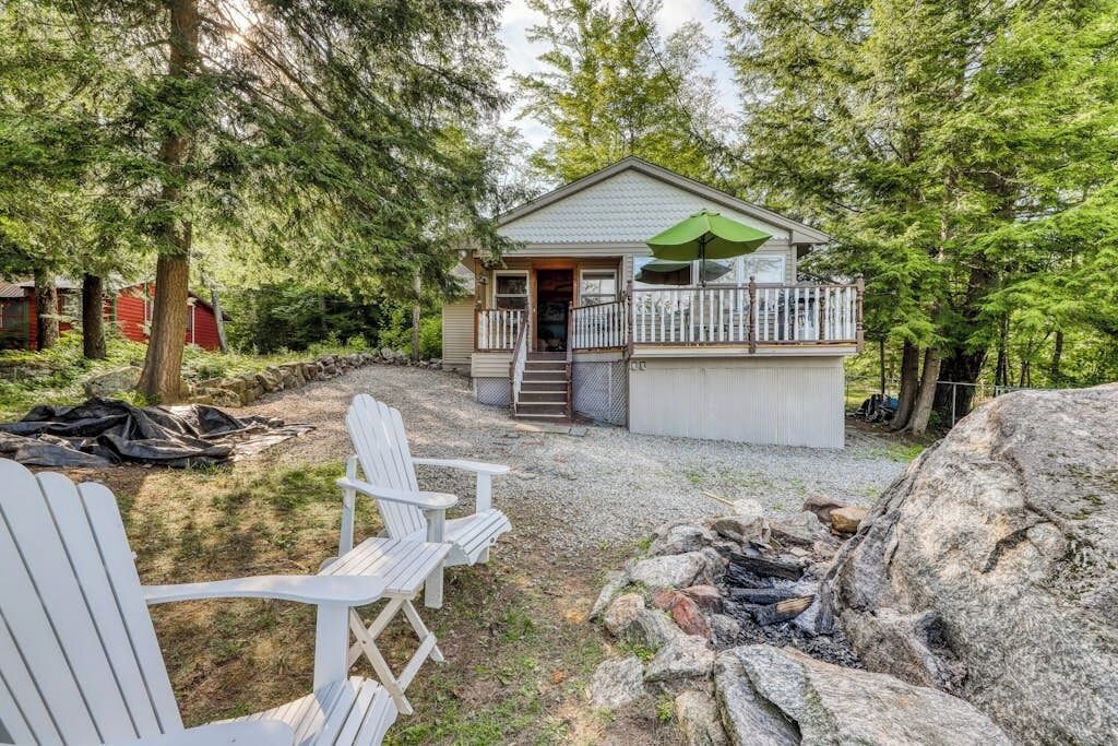 A cabin with a porch, outdoor seating, and a fire pit.