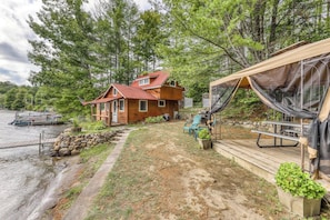 A cabin with a dock, a covered deck, and a small garden. - Beautiful 1BR Lakefront Adirondacks - Dock (Chestertown)