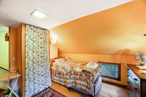 A bedroom with a bed, a window, a fan, and a lamp. - Classic 2BR Riverfront Adirondacks - Deck (Chestertown)