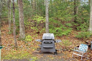 Ein Campingplatz mit einem tragbaren Grill und einem Klappstuhl.