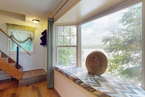 A staircase with a wooden handrail and a patterned rug on the landing. - Willow Bluff | 3 BR lakefront house with private beach & dock (Keuka Park)