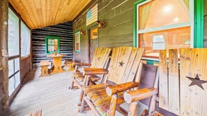 Ein Holzblockhaus-Interieur mit Holmöbeln, einem Tisch und einem Fenster mit Vorhängen.