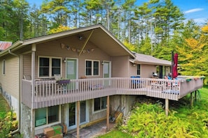 A two-story cabin with a covered deck and a small porch.