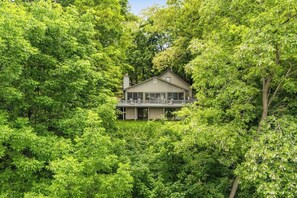 A house surrounded by dense green foliage. - Gorgeous 3BR Lakeview Adirondacks Dog Friendly (Hague)