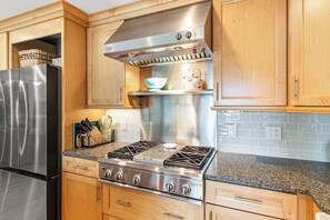 A kitchen with wooden cabinets, a stainless steel refrigerator, a gas stove, and a built-in oven. - Gorgeous 3BR Lakeview Adirondacks Dog Friendly (Hague)