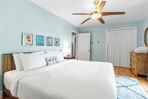 A bedroom with a bed, a ceiling fan, a door, and a dresser. - Gorgeous 3BR Lakeview Adirondacks Dog Friendly (Hague)