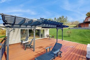 A covered outdoor deck with a pergola, seating area, and a view of a house. - Lakeview Retreat w/Gym, Deck & Stunning Seneca (Burdett)