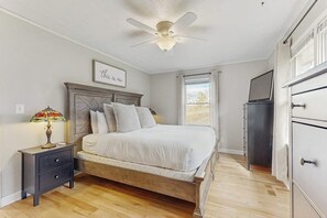 A bedroom with a bed, a nightstand, a ceiling fan, a dresser, and a window. - Lakeview Retreat w/Gym, Deck & Stunning Seneca (Burdett)