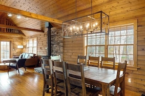 Un intérieur en bois comprenant une table à manger, des chaises, un canapé et une cheminée.