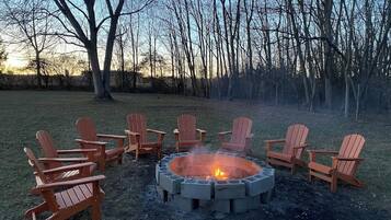 A circular fire pit with chairs around it in an outdoor setting.