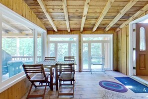 A wooden interior with a dining table and chairs, large windows, and a door. - 3BR mountain-view house with fireplace (Thurman)