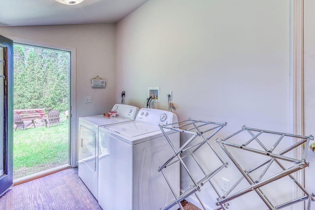 A laundry room with a washing machine, a dryer, and a drying rack.