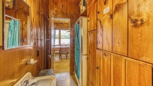 Un intérieur en bois avec un évier, un miroir et une vue sur un espace extérieur.