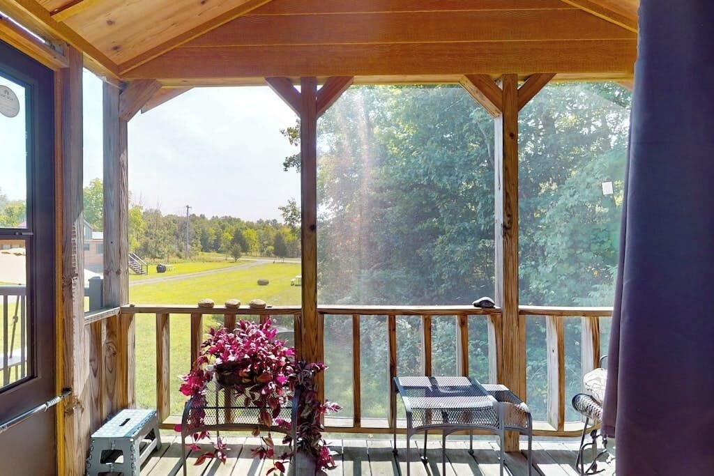 A covered outdoor area with a wooden deck, a table, and chairs.