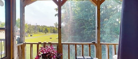 A covered outdoor area with a wooden deck, a table, and chairs.