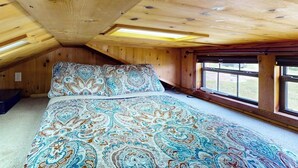 Una camera da letto con un letto grande, travi in legno a soffitto e una finestra vista.