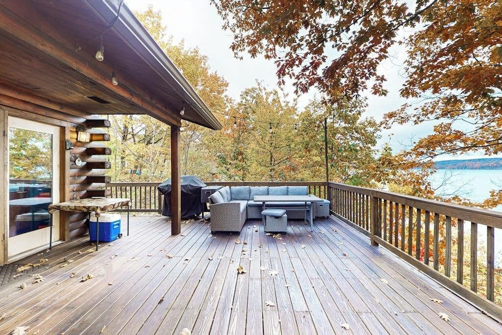 Eine Holzterrasse mit integriertem Sitzbereich und Blick auf einen See.