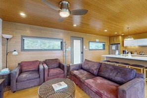 A modern living room with leather sofas, a coffee table, and a ceiling fan. - Contemporary 2BR Lakefront Finger Lakes (Dundee)