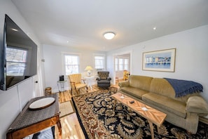 A living room with a sofa, armchairs, a coffee table, and a television. - Ideal 2BR Finger Lakes - Deck - withD (Hammondsport)