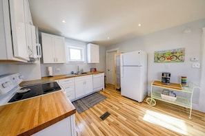 A modern kitchen with white cabinets, a wooden countertop, and a built-in stove. - Ideal 2BR Finger Lakes - Deck - withD (Hammondsport)