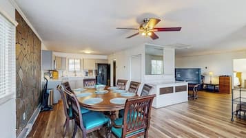 A dining area with a round table, chairs, and a ceiling fan.