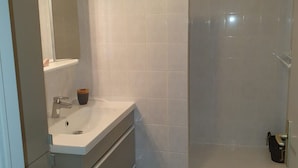 Ein Badezimmer mit Waschbecken, Spiegel und Dusche.