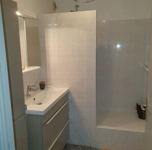 A bathroom with a white sink, mirror, and shower. - 2-bedroom apartment with terrace and parking (La Seyne-sur-Mer)