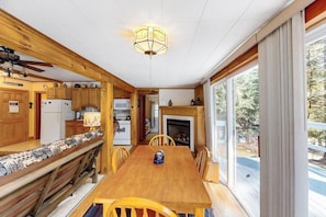 A wooden interior with a dining table, chairs, and a fireplace. - 3BR dog-friendly cottage with wrap-around deck (Chestertown)
