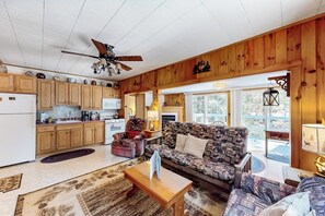 A cozy living room with a patterned sofa, a wooden coffee table, and a ceiling fan. - 3BR dog-friendly cottage with wrap-around deck (Chestertown)