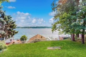 A lakeside property with a grassy lawn, a wooden deck, and a view of the lake. - 2BR lakefront home with grill - great views (Jerusalem)