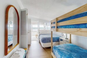 A room with bunk beds, a wooden-framed mirror, a white bedside table with a lamp, and a view through an open door. - 2BR lakefront home with grill - great views (Jerusalem)
