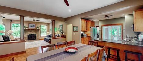 Un amplio espacio habitable con una mesa de comedor, sillas de madera y una chimenea.