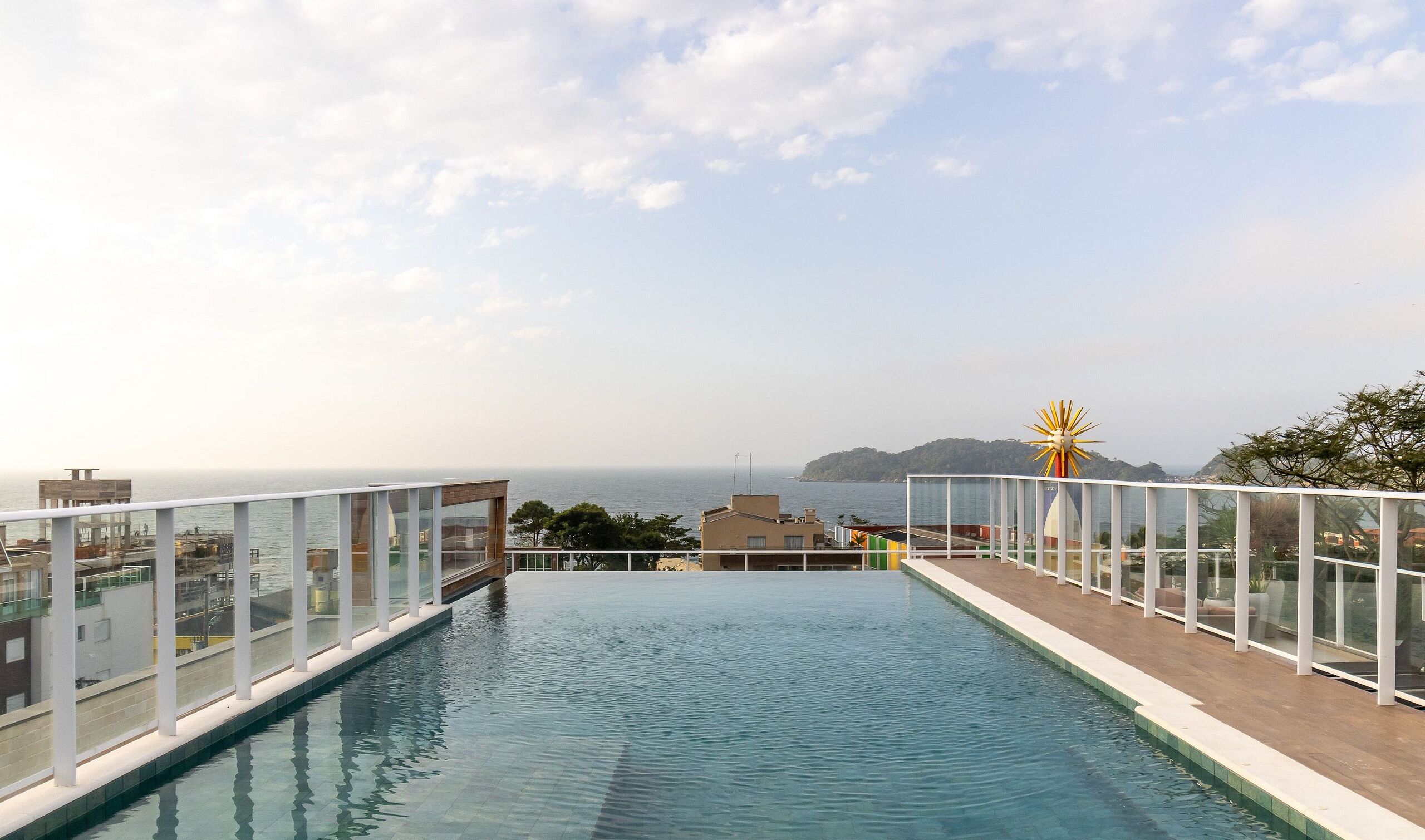 Ein Dachpool mit Infinity-Kante und freiem Blick auf das Meer und eine entfernte Insel.