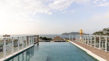 Ein Dachpool mit Infinity-Kante und freiem Blick auf das Meer und eine entfernte Insel.