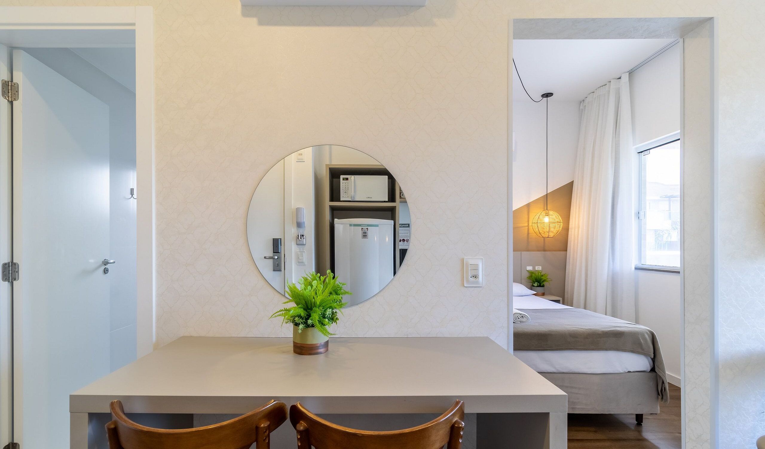 Ein kleines Hotelzimmer mit Essbereich, einem Bett und einem Badezimmer.