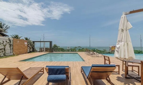 A swimming pool with lounge chairs and a table, overlooking a coastal view. - Sea View Apt w/ BBQ 50m From Beach Shc0606 (Picarras)