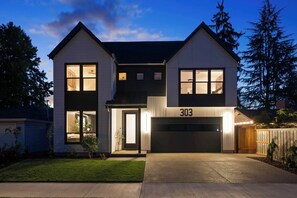 A two-story house with a garage, number 303, and a well-maintained front yard.
