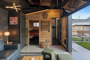 A modern interior with a wooden ceiling, a visible clock, and a glass door leading outside. - Luxury Designer Home -Private Oasis, Jacuzzi, Spa (Newberg)