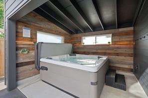 A hot tub in a wooden cabin with a window and a sign about hot tub safety rules. - Luxury Designer Home -Private Oasis, Jacuzzi, Spa (Newberg)